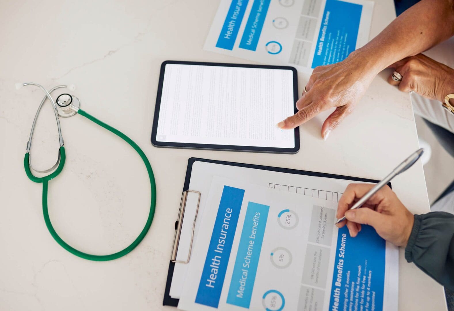 Health insurance documents and stethoscope on table