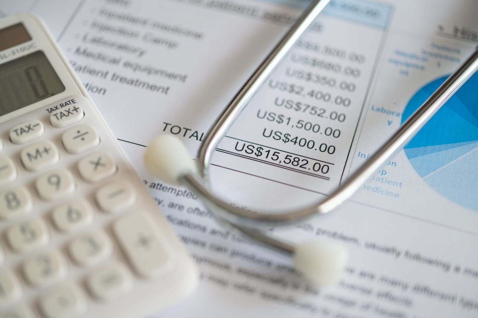 Calculator and stethoscope on medical bill